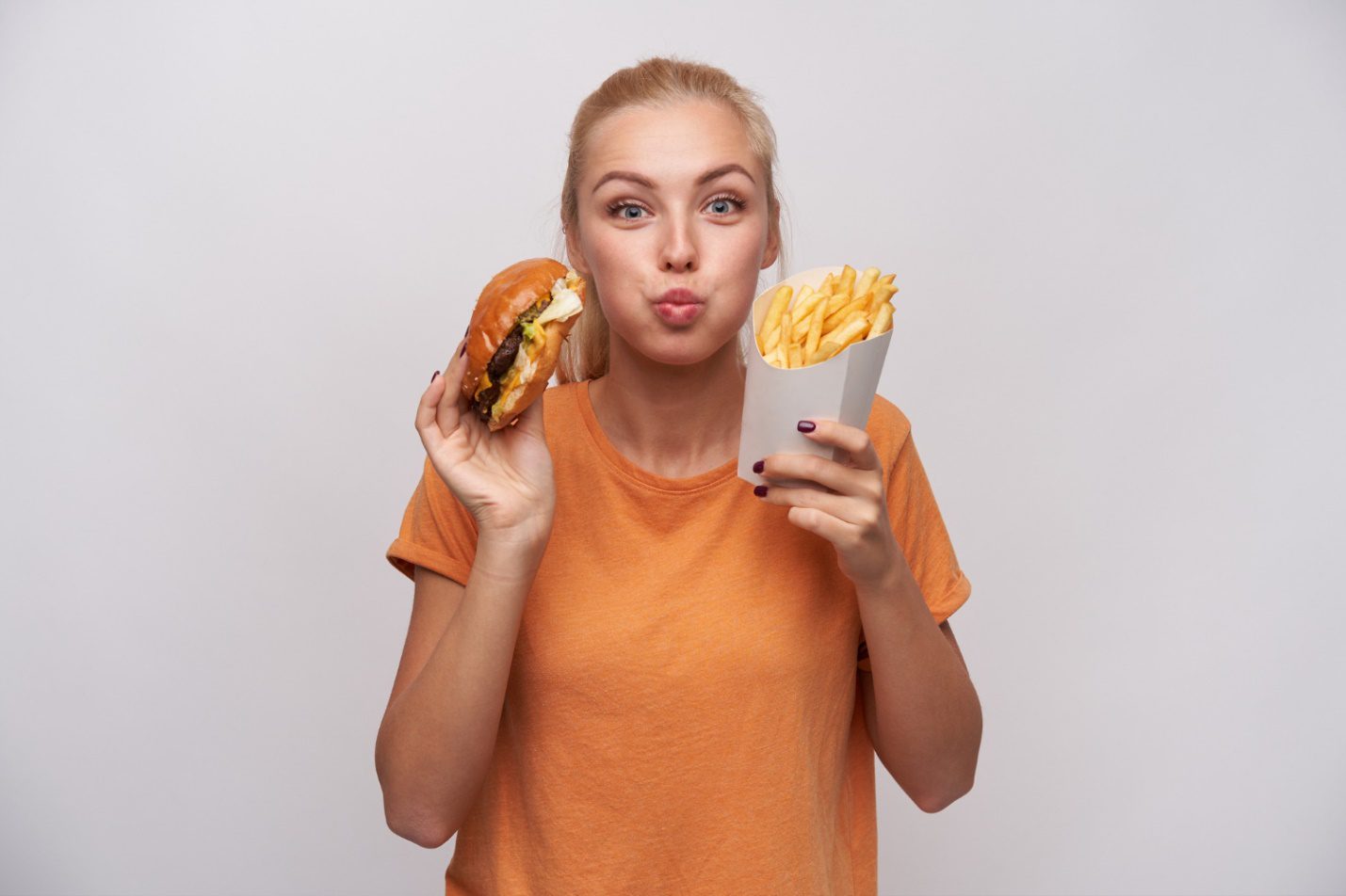 C:\Users\Dell\Downloads\portrait-charming-pretty-young-blonde-woman-holding-junk-food-looking-joyfully-camera-puffing-out-cheeks-being-excited-about-tasty-dinner-isolated-white-background.jpg